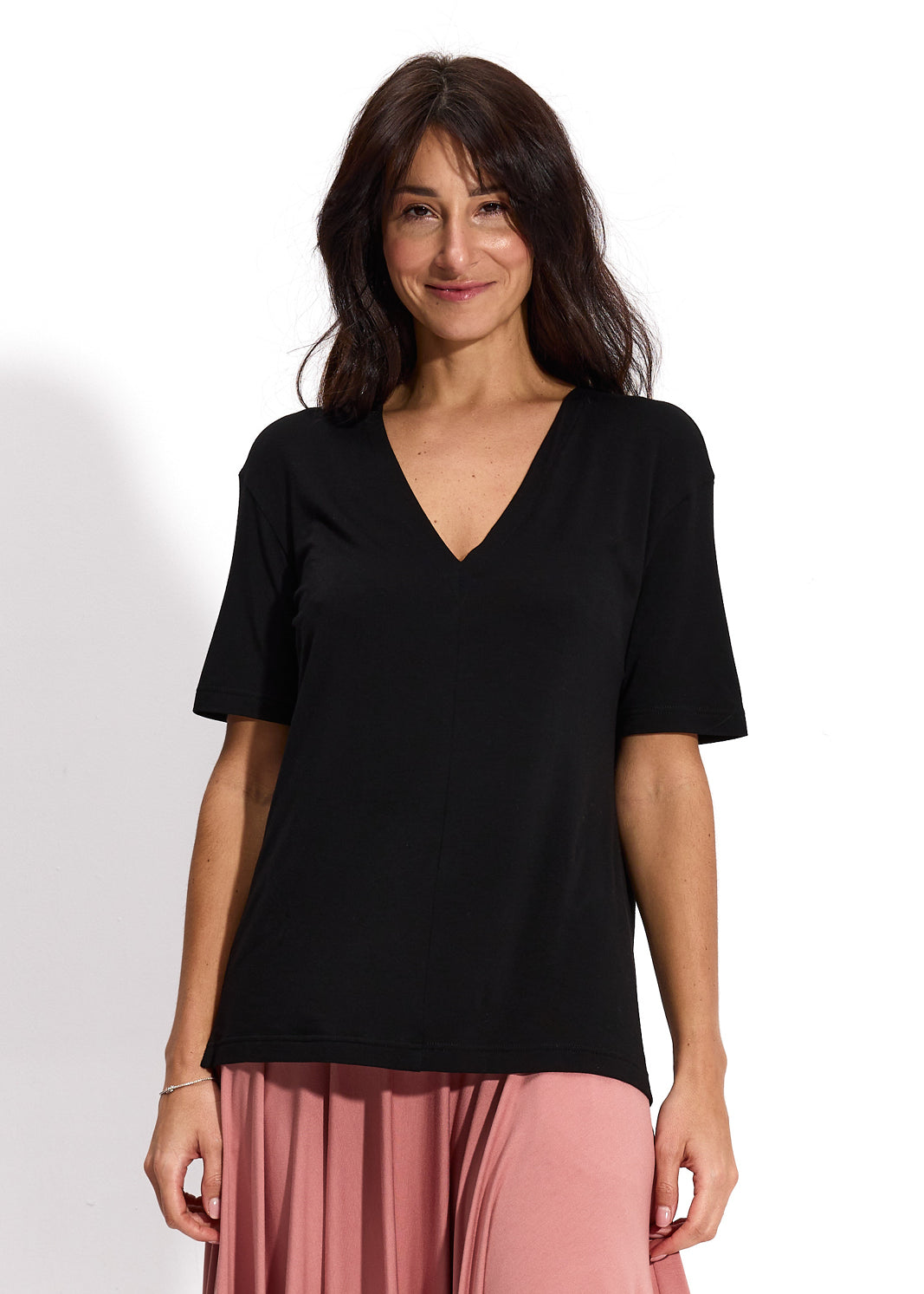 Czarna koszulka z dekoltem w serek i różowa spódnica – elegancka, wygodna stylizacja damska