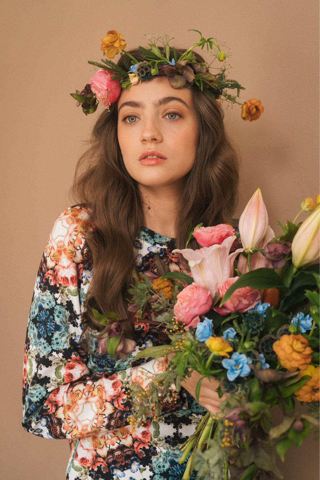Kobieta w kwiecistej sukience z wiankiem kwiatów, trzymająca bukiet róż i lilii – moda polska, self-care fashion