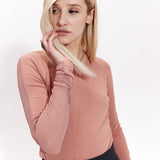 Różowy sweter z długim rękawem i czarna spódnica – elegancka stylizacja na co dzień