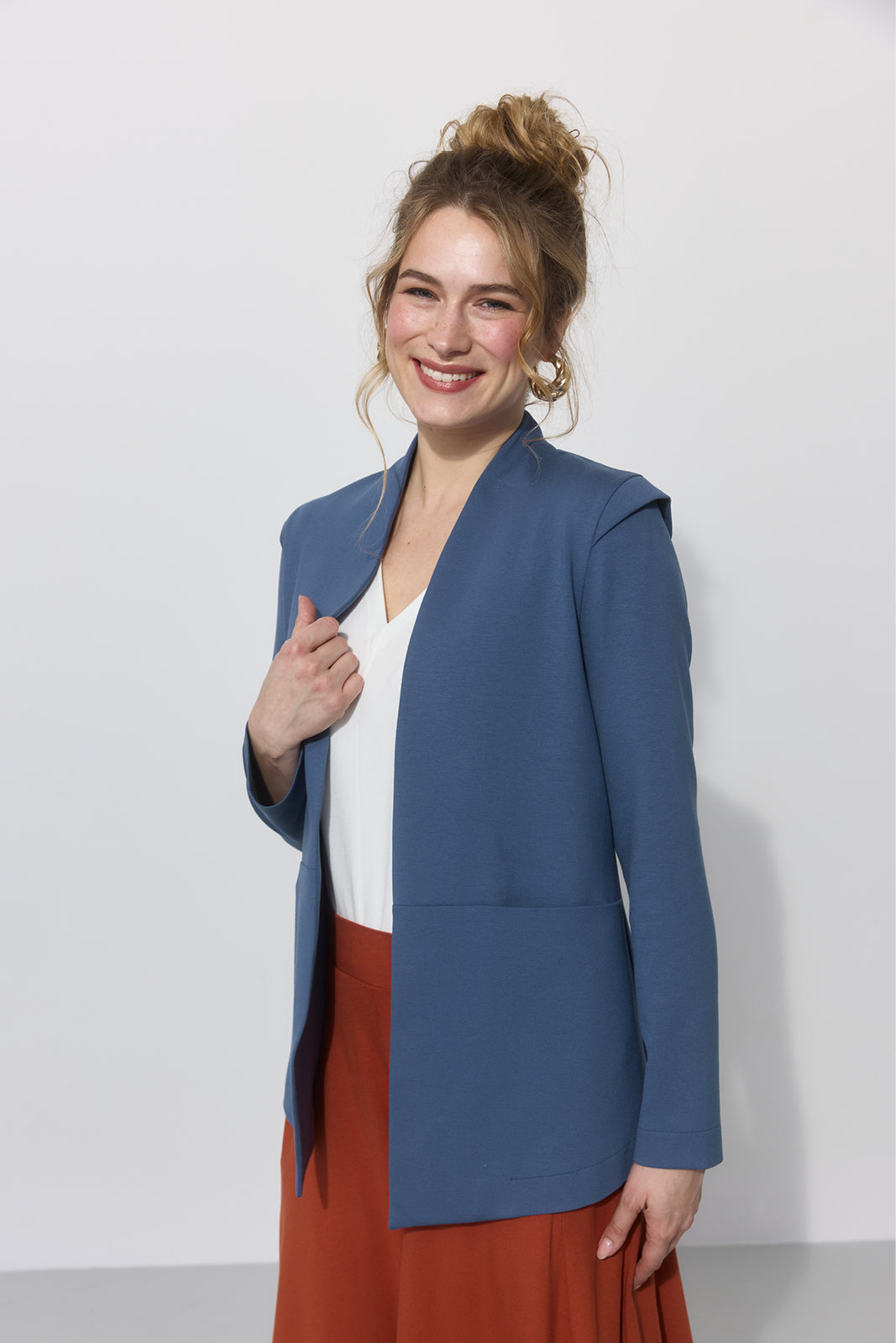 Niebieski płaszcz damski z białą bluzką i czerwoną spódnicą, stylowy i wygodny
