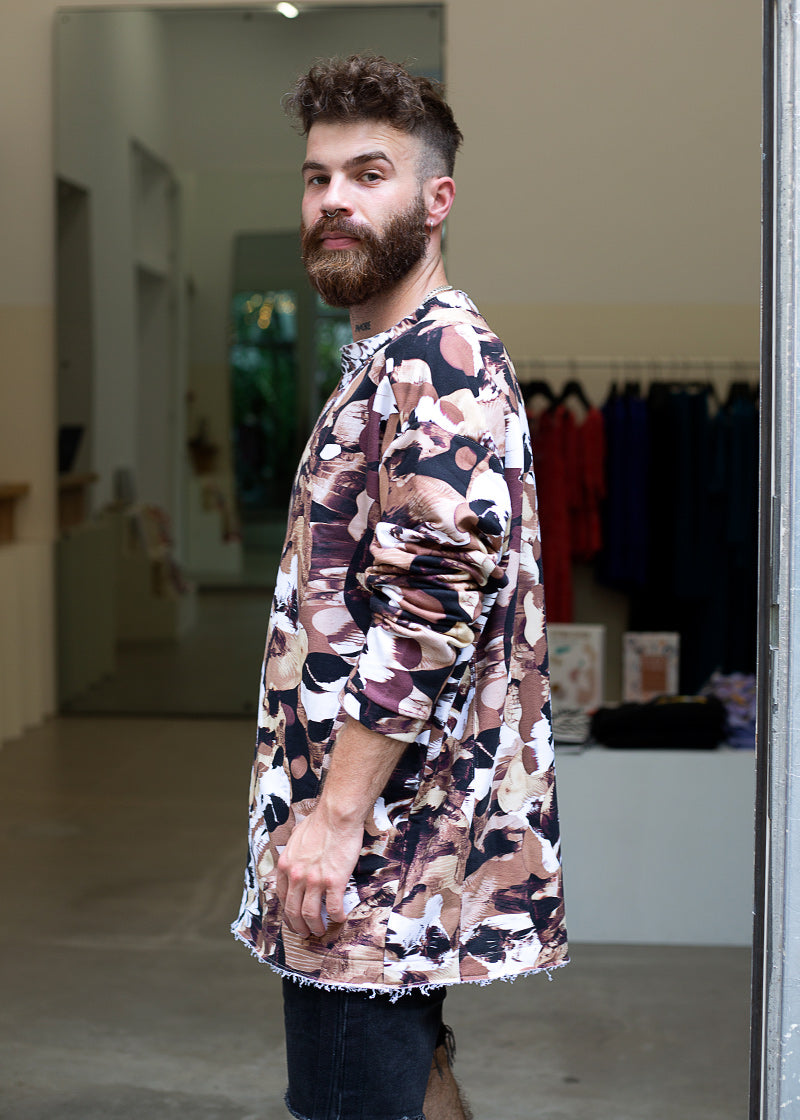 Mężczyzna w długiej koszuli z abstrakcyjnym wzorem, stylowy strój na co dzień, moda polska