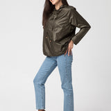 Kobieta w zielonej kurtce z kapturem, dżinsach i brązowych butach – stylowa i wygodna moda