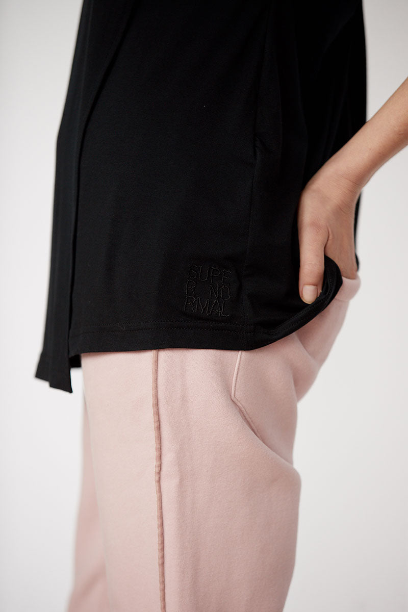 Czarna bluza z napisem 'SUPER NORMAL' i różowe spodnie – wygodny styl codziennego self-care fashion