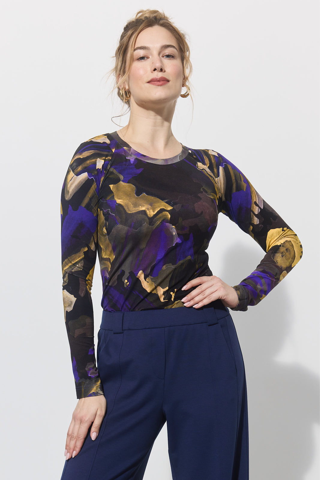 Kobieta w stylowej bluzce z abstrakcyjnym wzorem i granatowych spodniach, moda z kulturą i wygodą