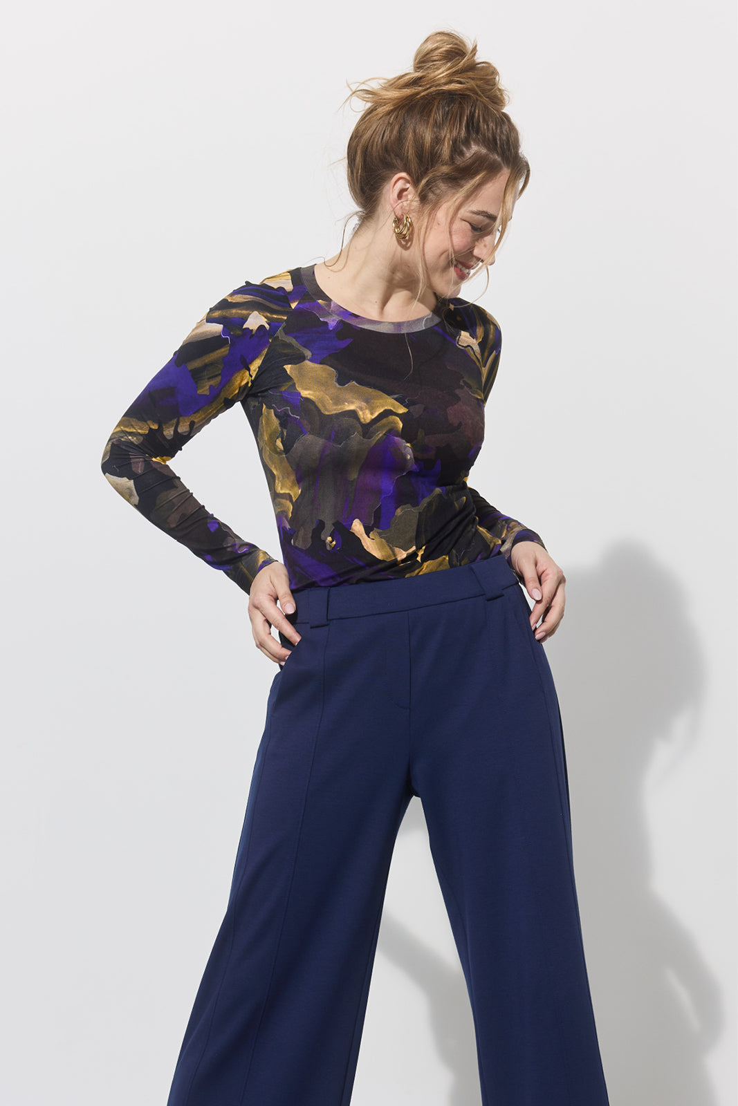 Kobieta w stylowej bluzce z abstrakcyjnym wzorem i granatowych spodniach, moda polska