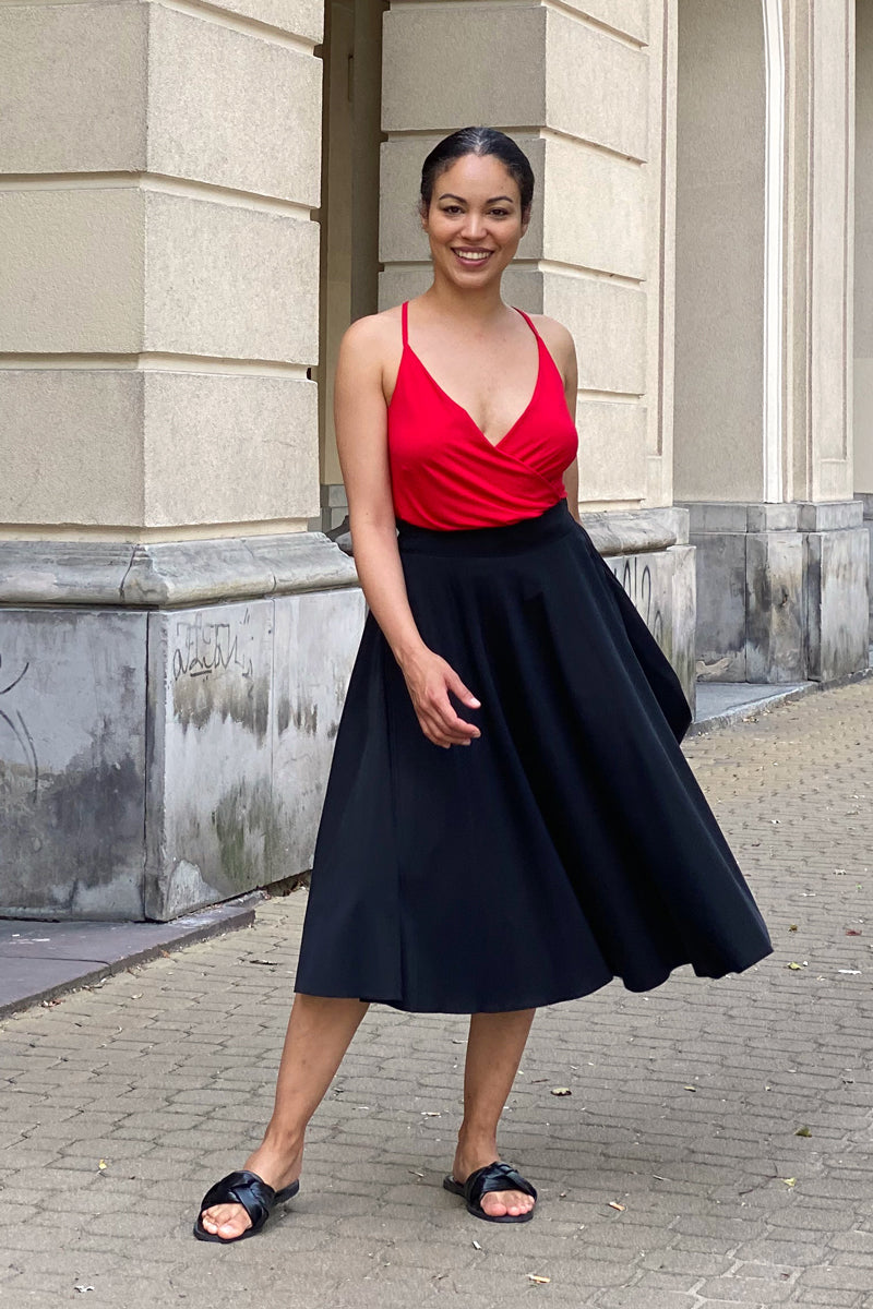 Czerwona bluzka z dekoltem w serek i czarna spódnica midi – elegancka stylizacja na co dzień