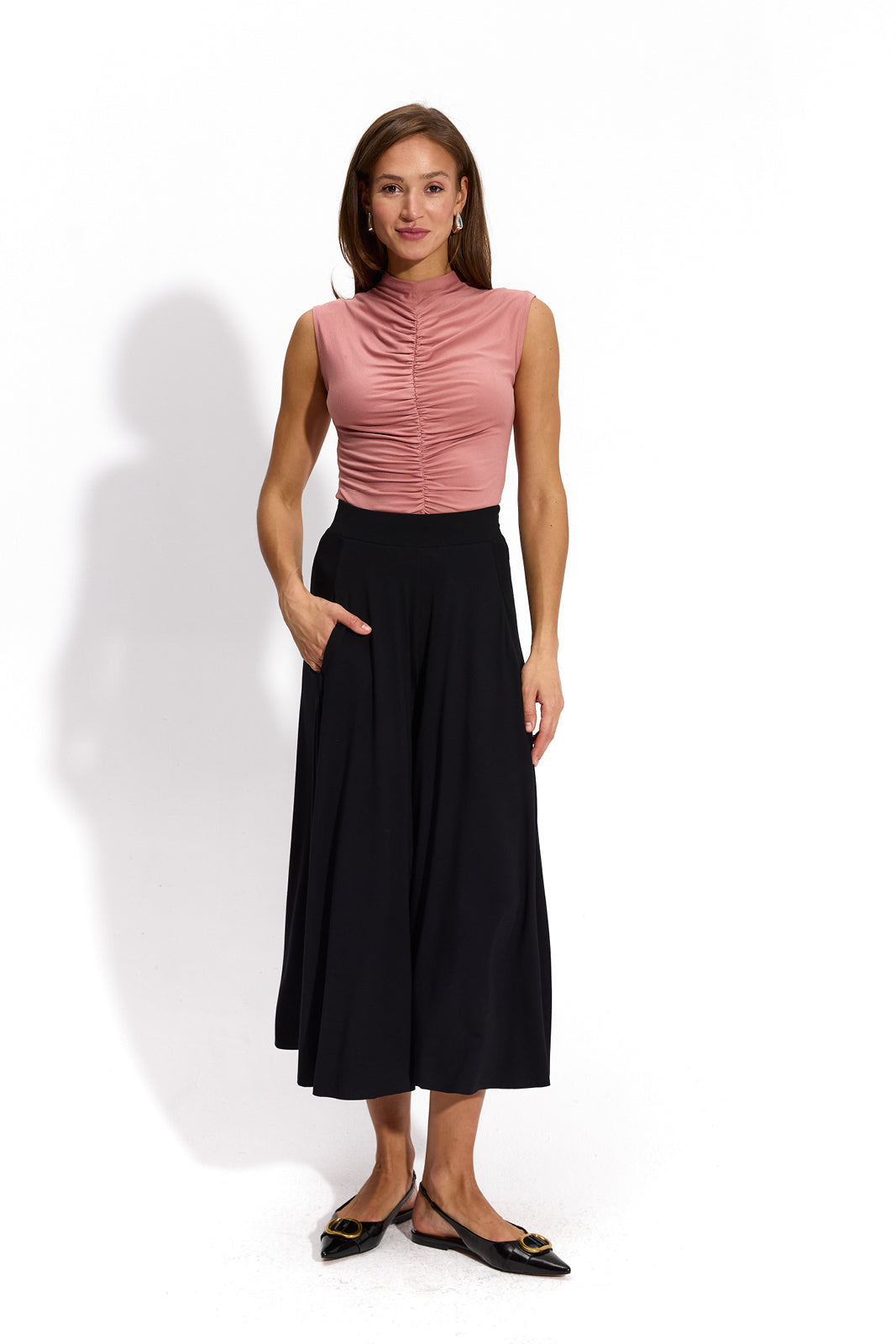 Różowa bluzka z marszczonym dekoltem i czarne spodnie culottes – elegancka stylizacja damska