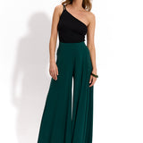 Kobieta w zielonych spodniach wide leg i czarnej bluzce jednoremieniowej, stylowa i wygodna moda