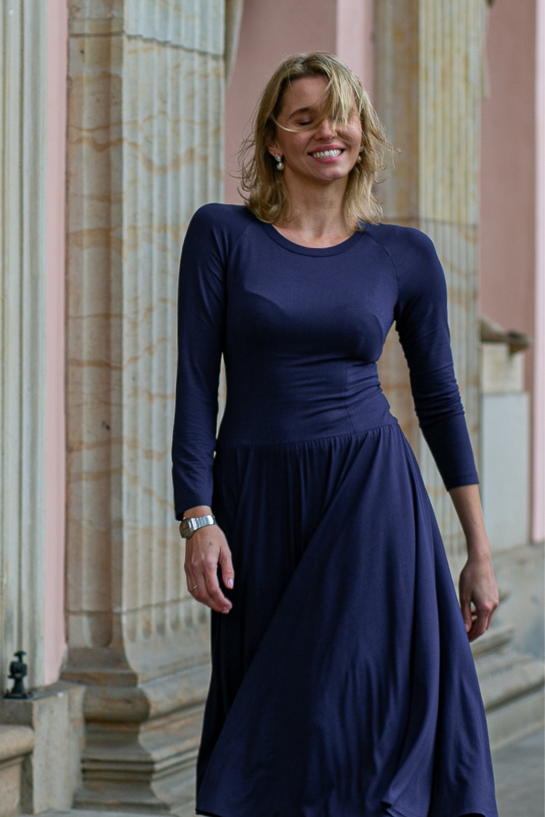 Kobieta w eleganckiej, granatowej sukience z długim rękawem, idealnej na codzienne stylizacje i wyjścia.