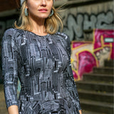 Sukienka z graficznym wzorem miasta, szara czapka, styl uliczny z graffiti na tle